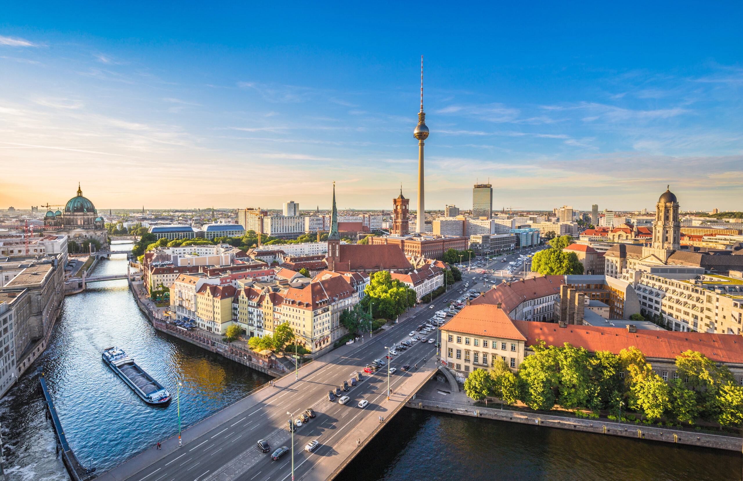 Germany - Berlin Aerial view of Berlin skyline at sunset with the Fernsehturm TV Tower, Berlin Cathedral, and boat traveling on the Spree River